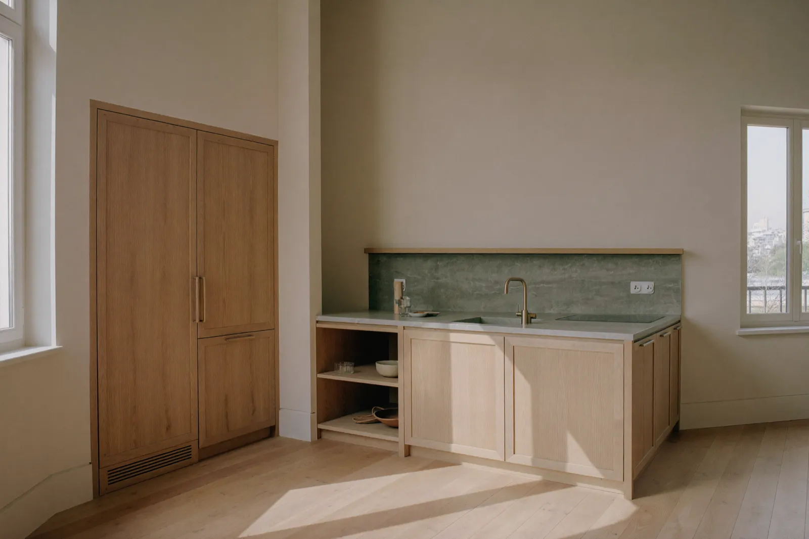 Cuisine en chêne clair sur mesure, façades sans poignée et plan en pierre, lumière du matin