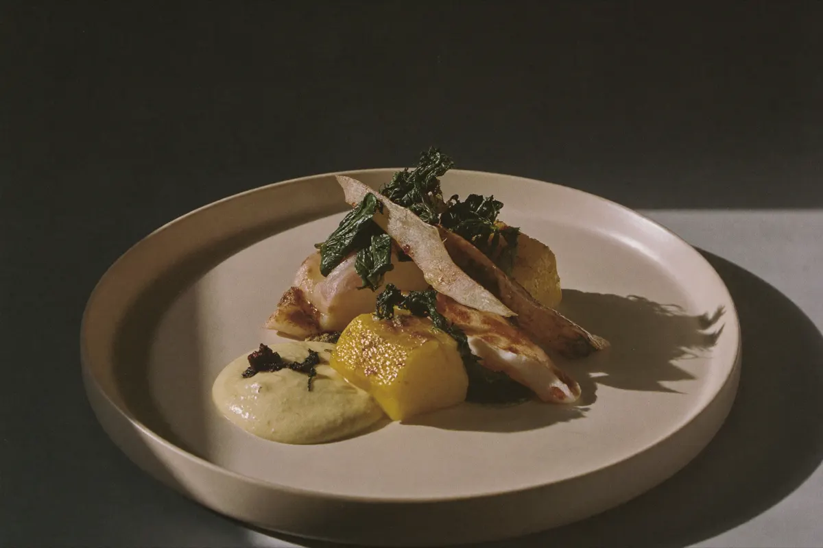 Assiette dressée : lieu jaune, algue et beurre fumé sur céramique crème