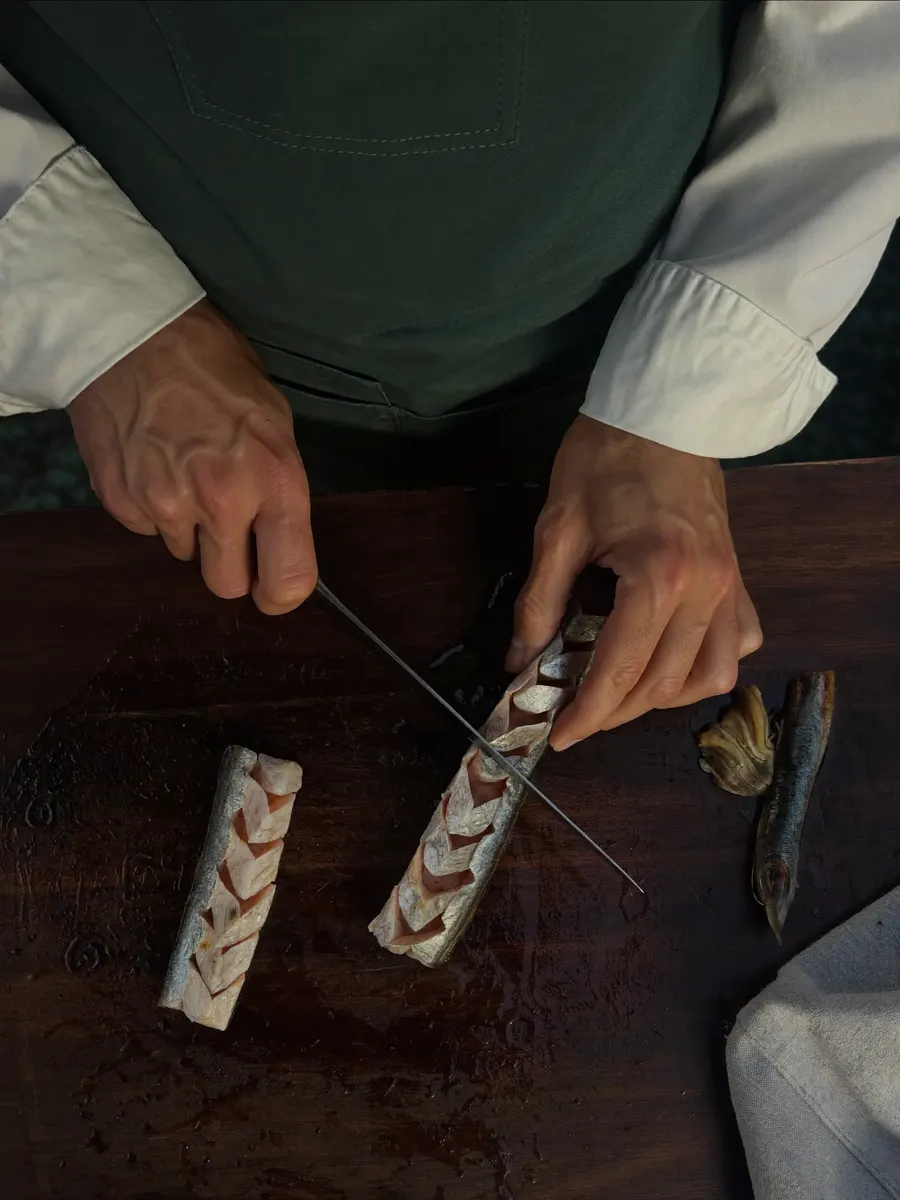 Mains levant un filet de poisson au couteau