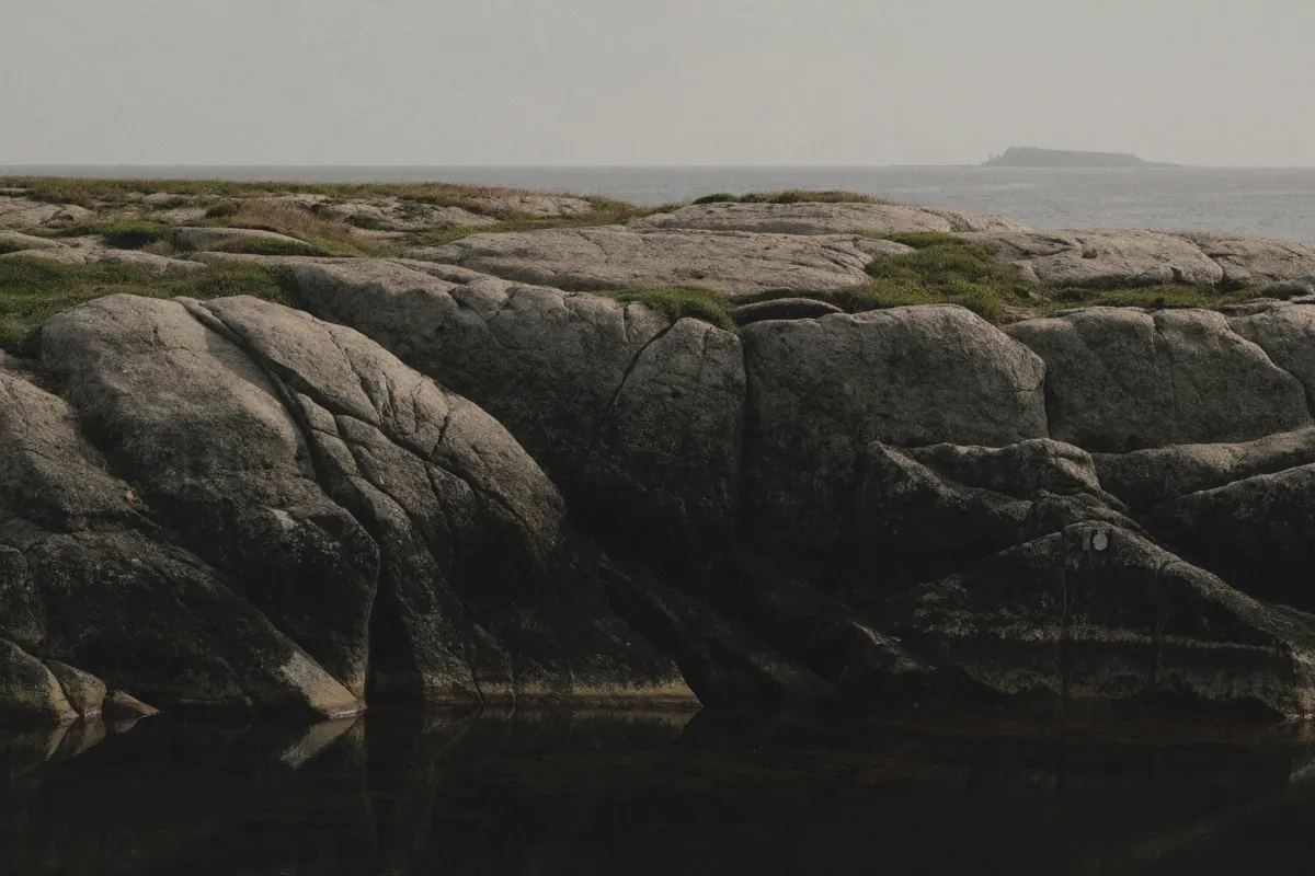 Pointe de granit en Finistère, roche sombre et mer grise