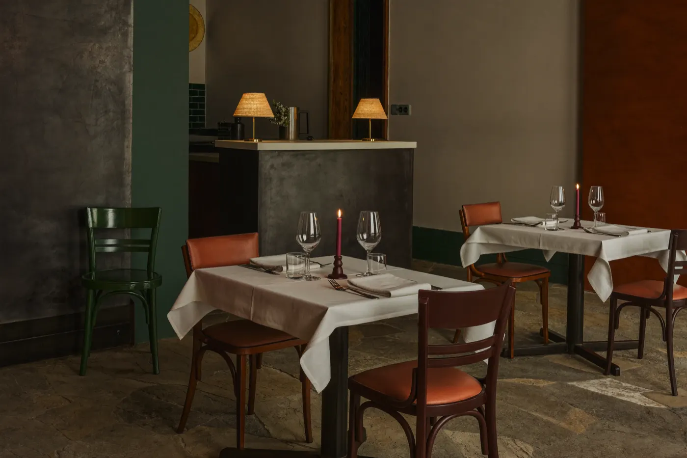 Deux tables dressées, bougies et lampes basses